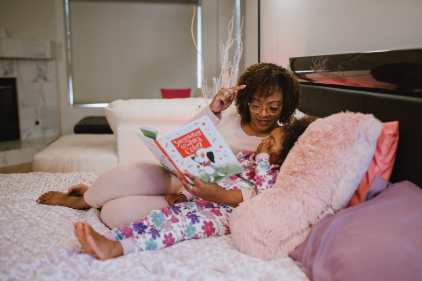 A loving mother reads a bedtime story to her daughter, creating a warm bonding moment