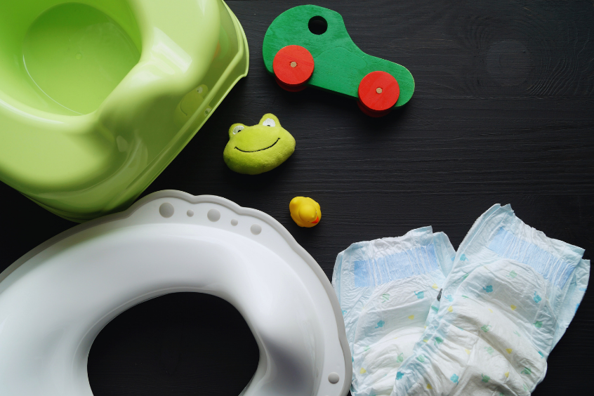 Potty training supplies including a child’s toilet seat, diapers, and toys